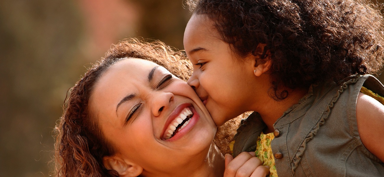 young child kissing mom's cheek